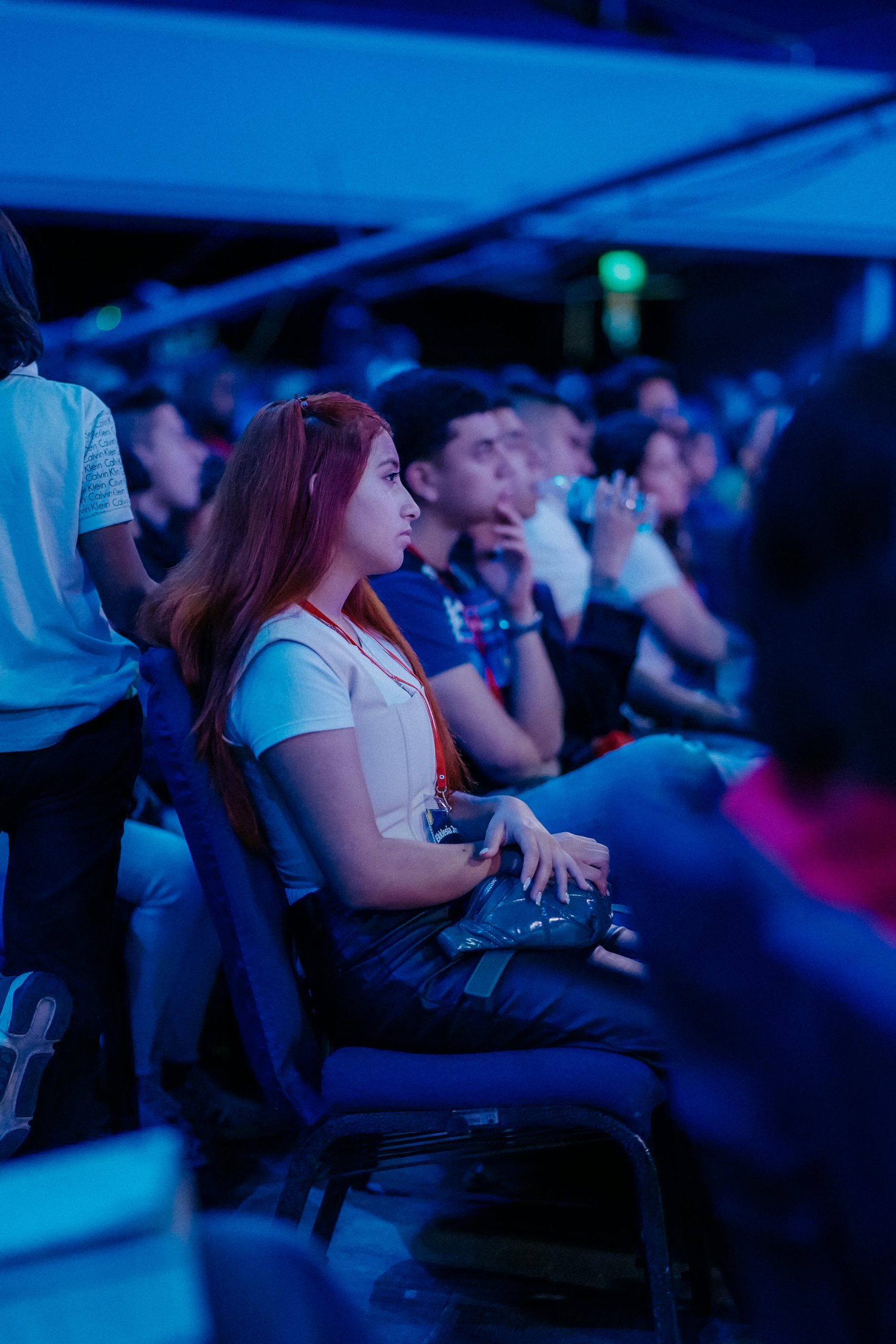 A group of people attentively sitting indoors during an evening event.